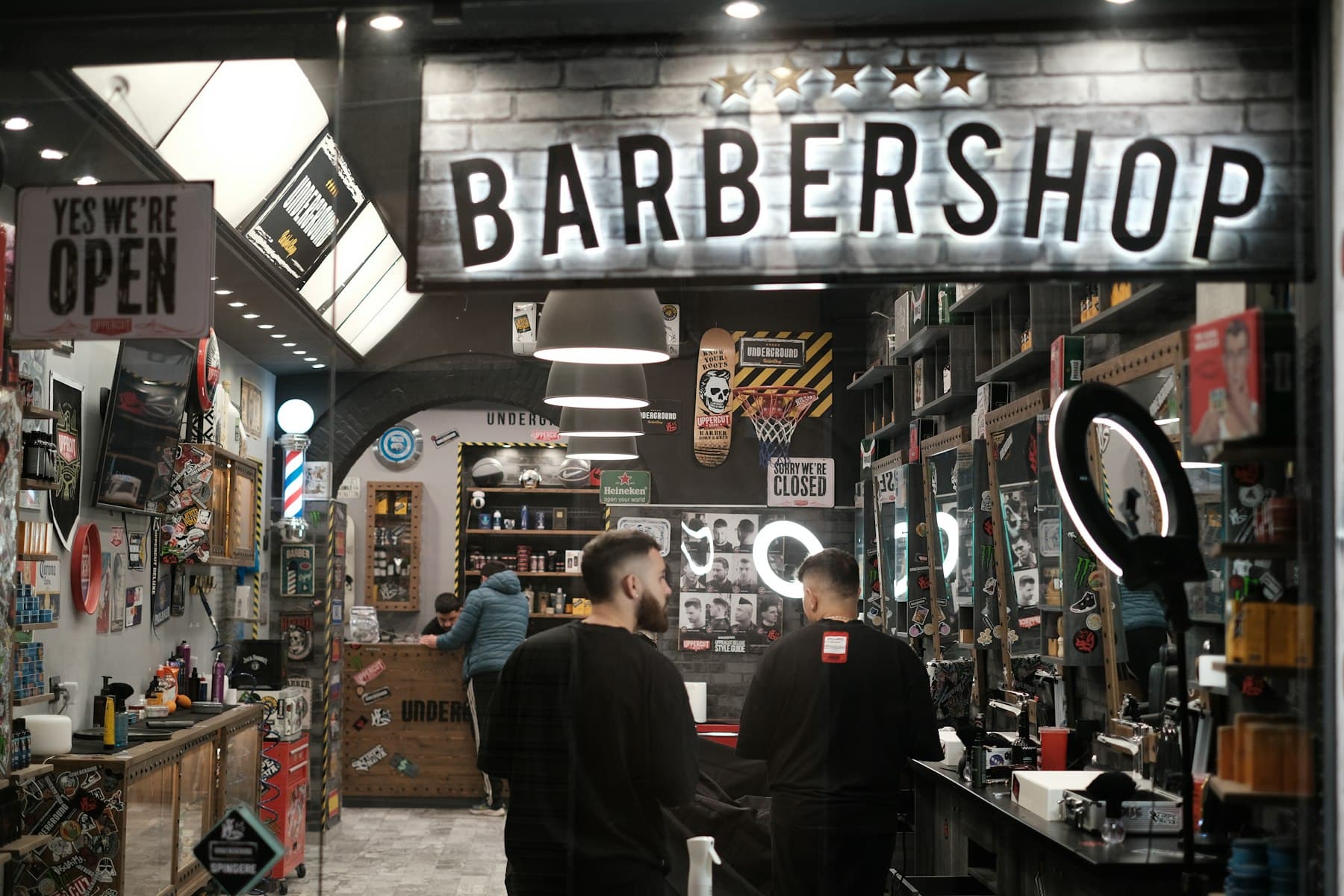 Fachada e interior de la barbería en hora punta